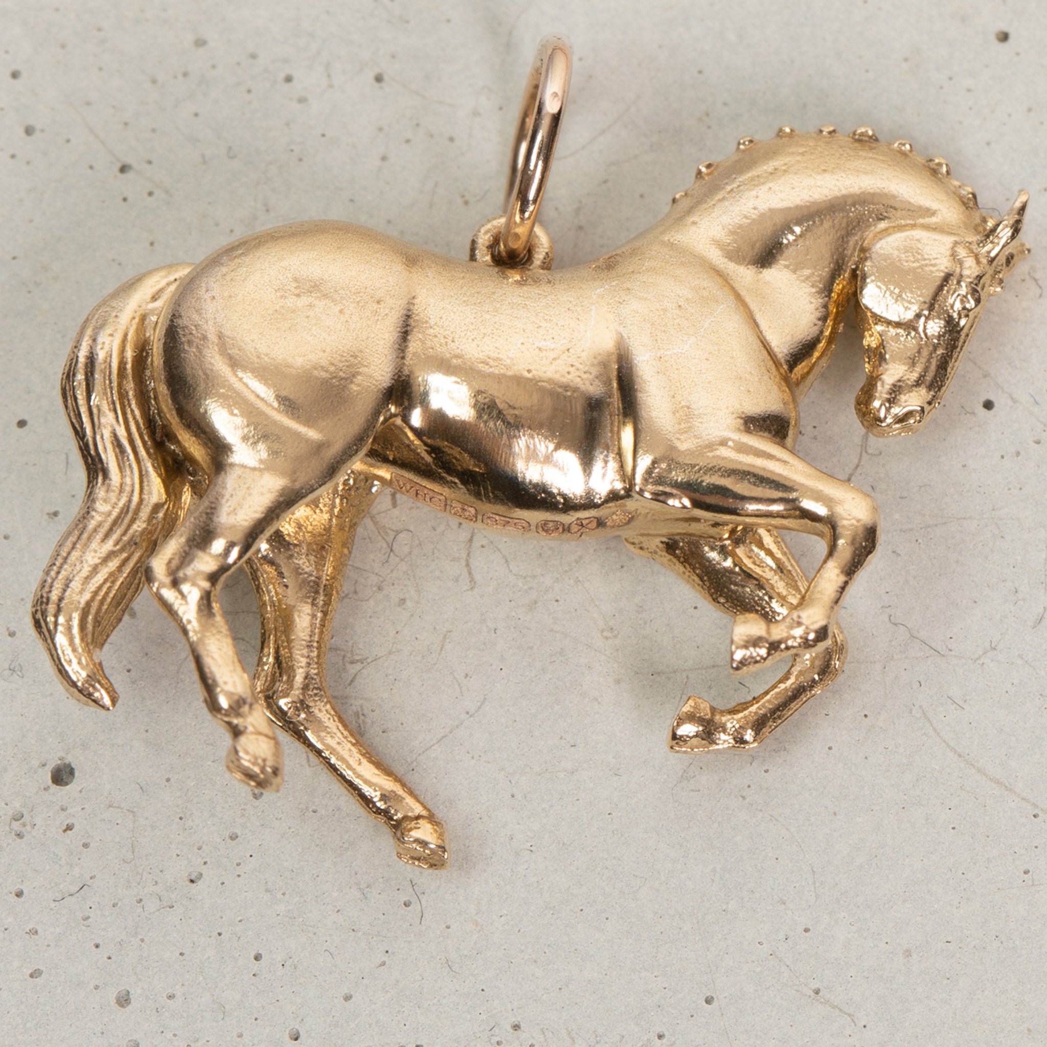 A close-up of a large horse pendant necklace in Gold Vermeil, a piece of equestrian jewelry.