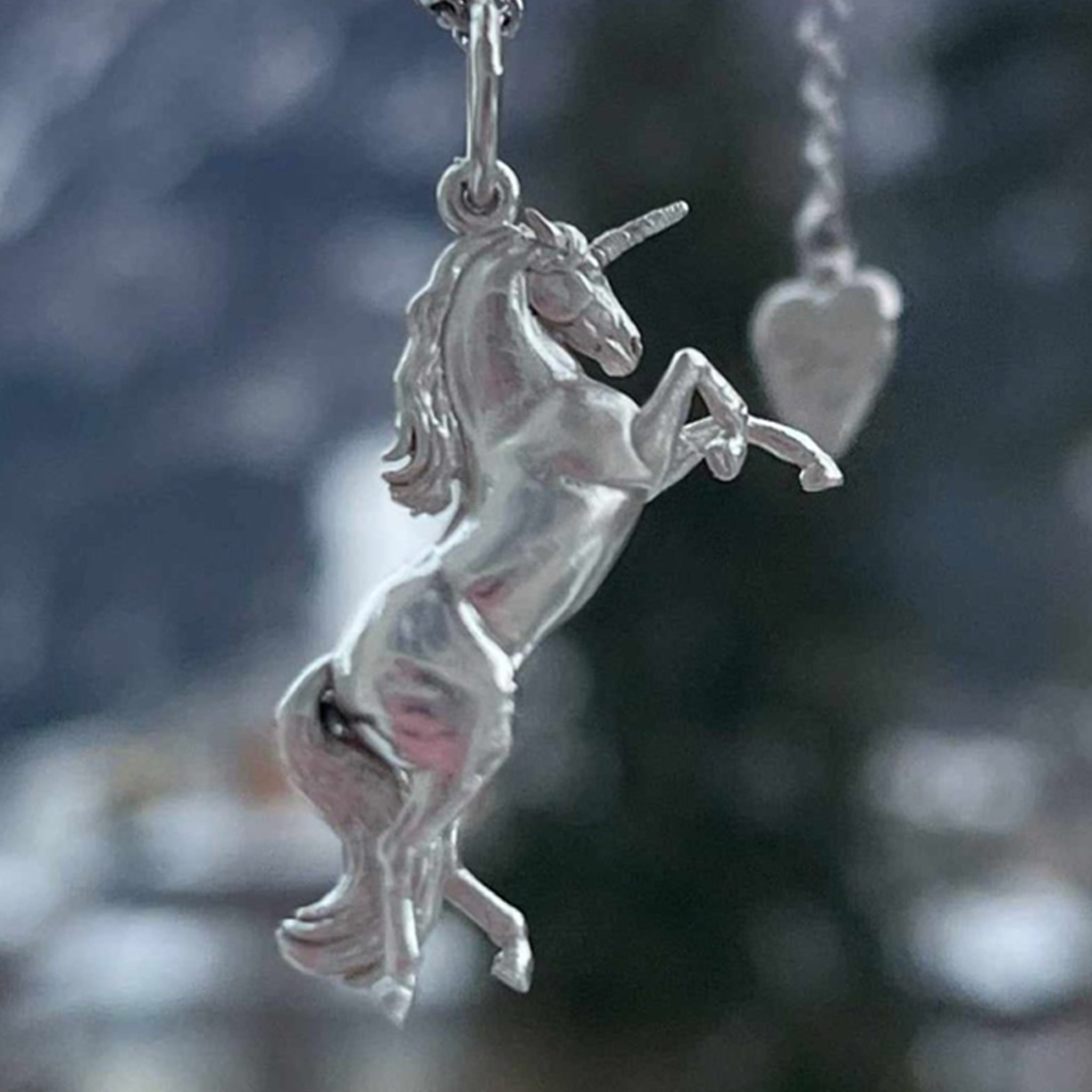 a sculpted sterling silver horse pendant hanging from a delicate ball chain, showcasing the fine detail of the horse jewelry design.