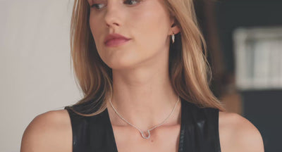 A short video of a woman wearing a beautiful silver horseshoe necklace and horseshoe earrings.